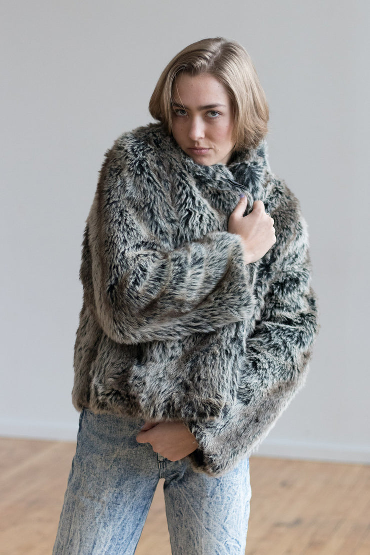 Woman in faux fur coat with acid wash jeans 90s style