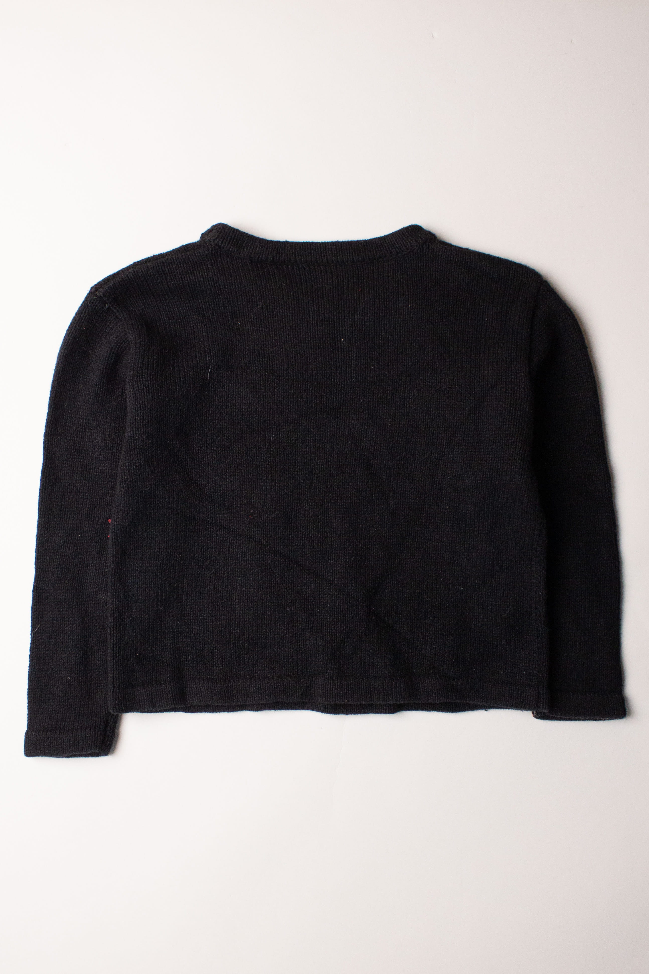 Kids black ugly Christmas pullover sweater laid flat showing the back side on white background