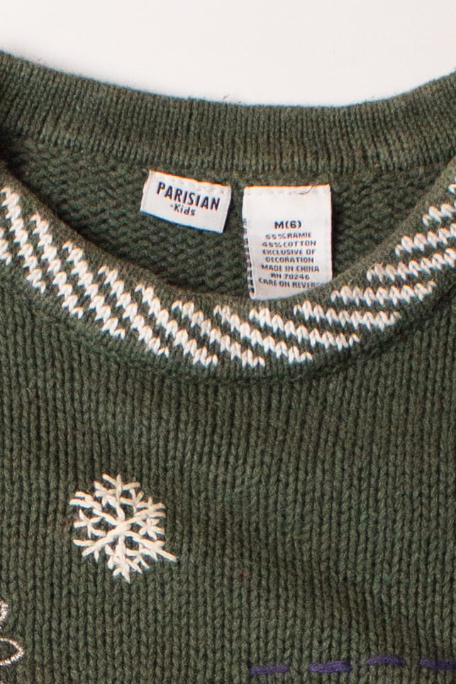Close-up of kids green ugly Christmas pullover with snowflake embroidery and clothing labels inside collar