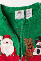 Close-up of kids green ugly Christmas cardigan with Santa, reindeer, and snowman appliques and a zipper front closure